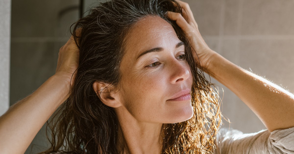 Femme appliquant un soin à l'adénosine sur son cuir chevelu, cheveux humides
